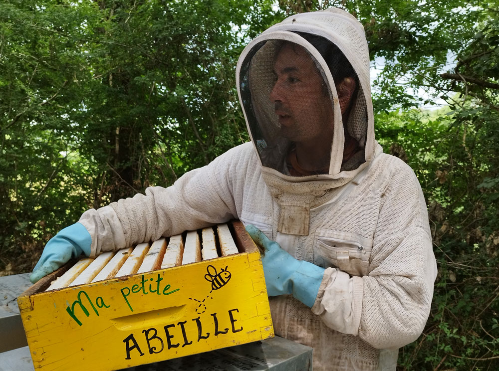Alexandre Blois avec une ruche dans les bras au couleurs de Ma Petite Abeille